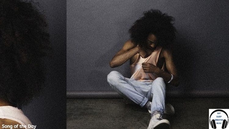 Black man in tank top jeans, and sneakers sitting against a wall | Lake Sovall "Lace" song of the day feature | Eat Sleep Breathe Music