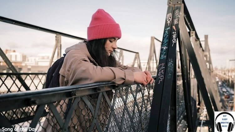 Girl on a Bridge with a pink hat Song of the day "Ghost Town" by Delyn Grey |