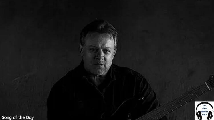 TIm Haverman of SD17 wearing a black shirt holding a guitar