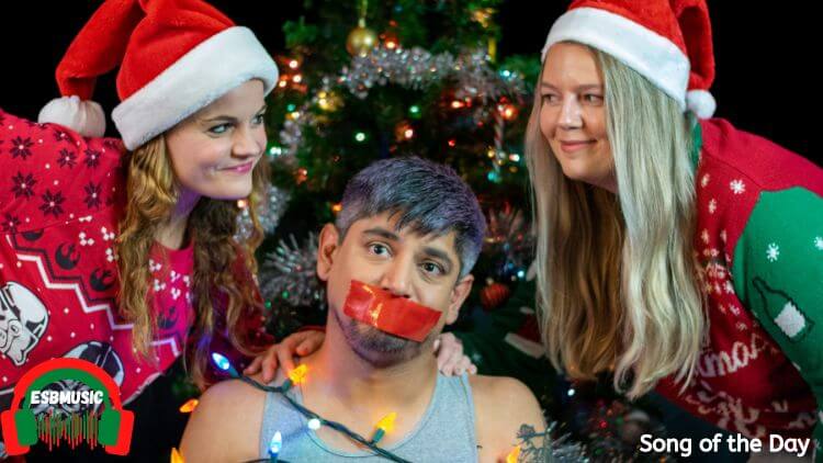 Canadian Broadtree Member Armand Antony Sitting in a chair tied up with tape over his mask while other Broadtree member Nicole McCafferty & Canadian country singer Armand Antony stand over him smiling with chrismtas gear on | Song of the Day: “Don’t Come Home for Christmas” by Broadtree & Maddie Corinne | Eat Sleep Breathe Music